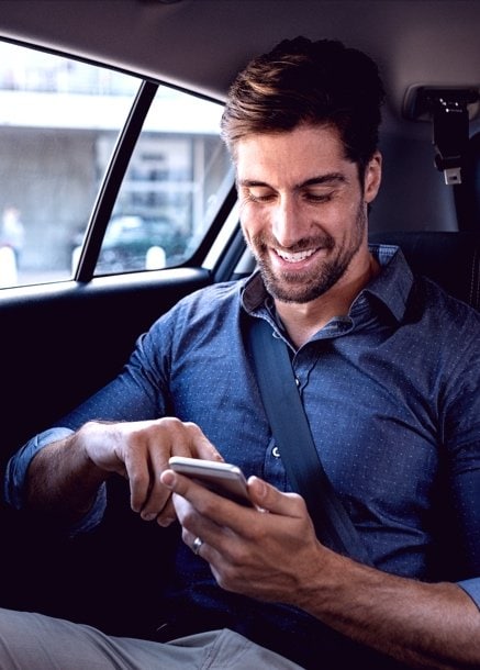 Guy looking at mobile phone with open banking solutions